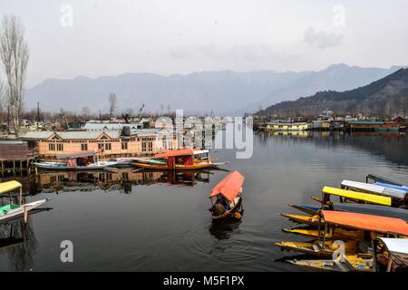 Srinagar, India. 23rd Feb, 2018. A Kashmiri boatman rows a boat on the interior waters of Dal lake in Srinagar, Indian administered Kashmir. Dal is a lake in Srinagar, Indian administered Kashmir. The urban lake, which is the second largest in the state, also known as the 'Jewel in the crown of Kashmir.'' It has for centuries captured the imagination of writers, poets and film makers and it is integral to the tourist trade. Kashmir has been a contested land between neighboring nations India and Pakistan since 1947, the year that both countries attained freedom from British rule. (Cred Stock Photo