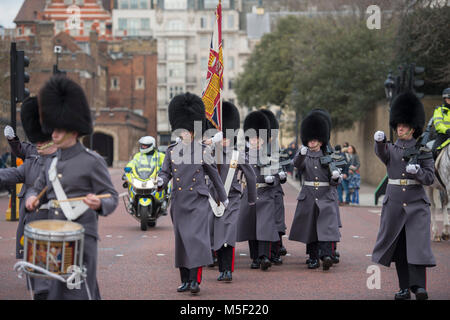Westminster, London, UK. 23 February 2018. Tourists brave bitterly cold wind to watch the Changing the Guard ceremonies at St James’s Palace and Buckingham Palace. Scots Guards leave St James’s Palace accompanied by Pipes and Drums of the Irish Guards. Credit: Malcolm Park/Alamy Live News. Stock Photo