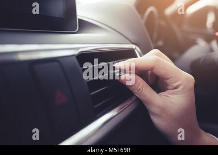 Closeup female hand adjusting air ventilation grille Stock Photo