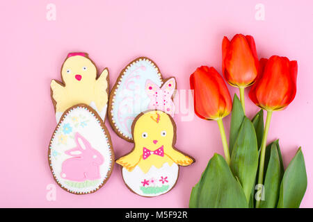 Easter gifts, sweet gingerbreads, flowers on pastel background. Studio Photo Stock Photo