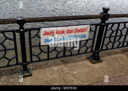 A warning sign in Malay by the Kuching Riverside, attempting to deter young people from drugs and alcohol with the threat of dying young Stock Photo