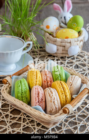 multicolored meringues macaroons in a basket for Easter Stock Photo
