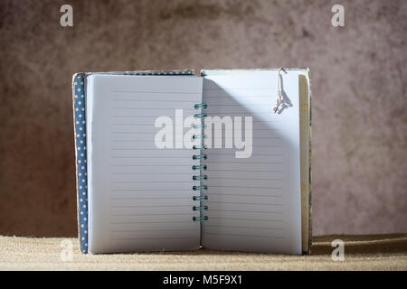 Blank lined notebook on a creative brown blurred background Stock Photo