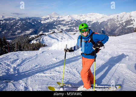 Happy male skier on skis in French Alps in winter snow skiing on red Marmotte ski slope above Samoens, Haute Savoie, Rhone-Alpes, France, Europe Stock Photo