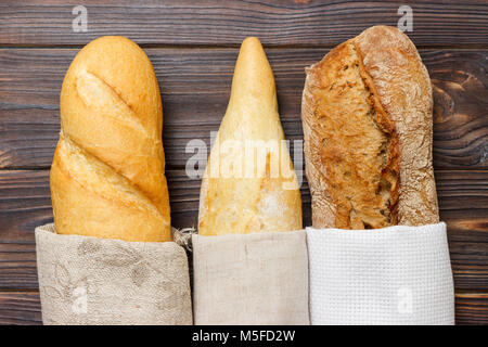 Loaf of bread in a bag european style on a rustic table. Stock Photo
