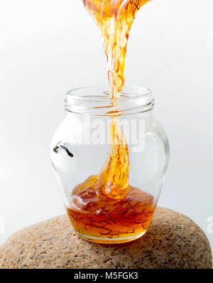 Jar with bee honey infused with saffron Stock Photo