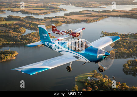 Two Vans RV-12 light sport aircrafts fly in formation together over the coastline of the Chesapeake Bay, Stevensville, Maryland. Stock Photo