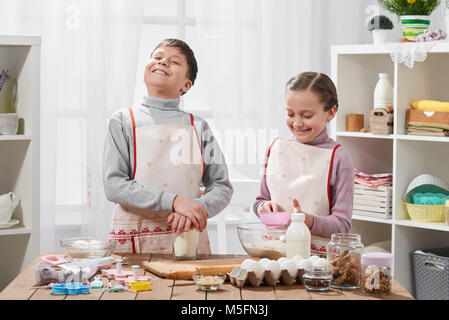 Girl and boy cooking in home kitchen, make the dough for baking, healthy food concept Stock Photo