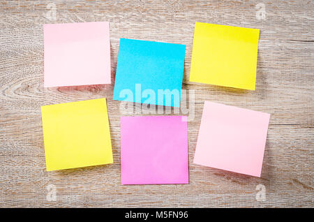 Blank colorful sticky notes on wooden background. Stock Photo