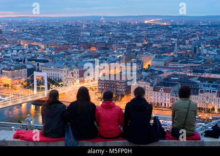 Group of sitting people overlooks Budapest city from top viewing point on Gellert hill Stock Photo