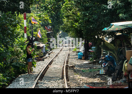 shacks inhabited by poor people on the edge of the railroad tracks in Bangkok Stock Photo