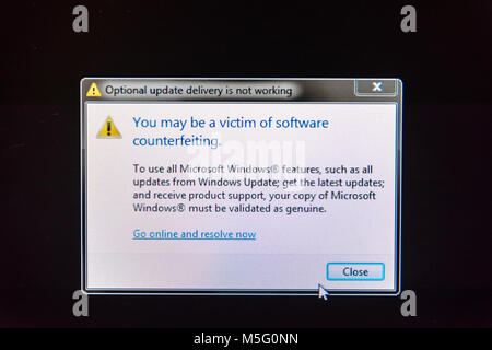 An error message is displayed on the screen of a computer warning that Windows Update has detected a non-genuine pirated version of Windows XP. Stock Photo