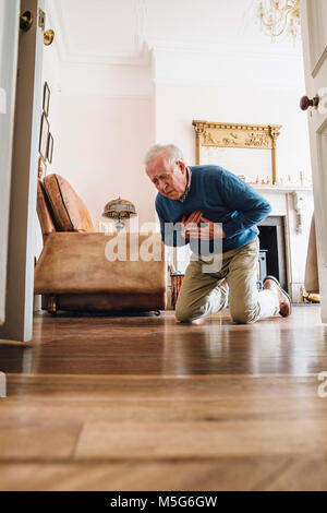 Senior man having a heart attack in his home. Stock Photo