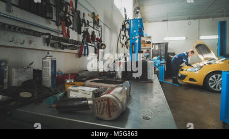 Mechanic in the garage, car preparing for repairing, wide angle - de-focused Stock Photo