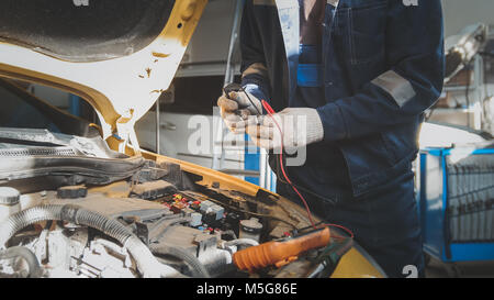 Mechanic works with voltmeter - car electrics - electrical wiring Stock Photo