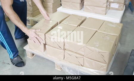 Factory worker on warehouse packing boxes for delivery Stock Photo