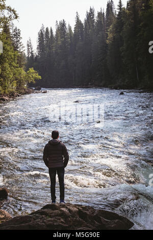 Man standing near waterfall Stock Photo