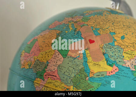 World with plaster with heart - Solidarity and aid to countries in need concept Stock Photo