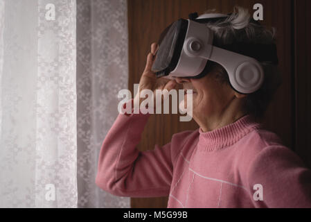 Senior woman using virtual reality headset Stock Photo