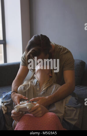 Couple kissing each other while playing video games Stock Photo