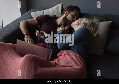 Couple kissing each other in living room Stock Photo