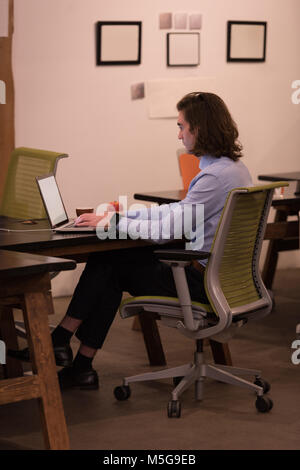 Male executive using laptop in office Stock Photo