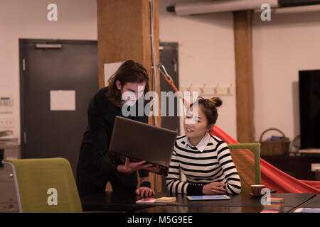 Female executives discussing over laptop Stock Photo