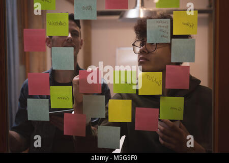 Business colleagues writing on sticky notes Stock Photo