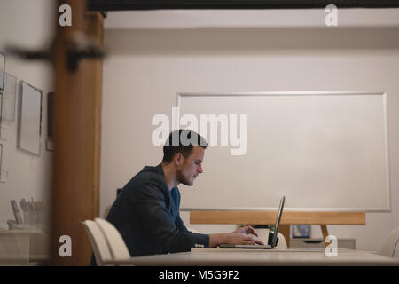 Businessman using laptop in conference room Stock Photo