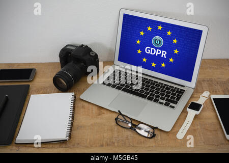 Composite image of laptop, wristwatch, notepad, camera and mobile phone on wooden table Stock Photo