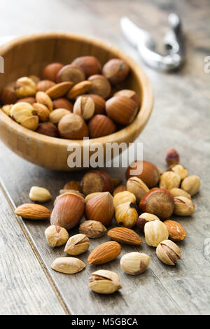 Assorted mixed nuts in bowl on wooden table Stock Photo