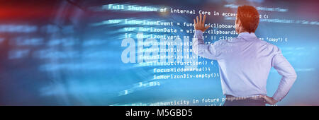 Composite image of rear view of businessman with hand on hip using invisible interface Stock Photo
