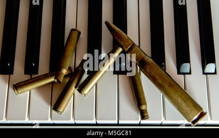 bullet shells on piano keys Stock Photo