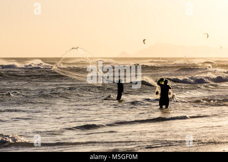 Fishermen at work during sunset, Barra da Tijuca beach, Rio de Janeiro Stock Photo