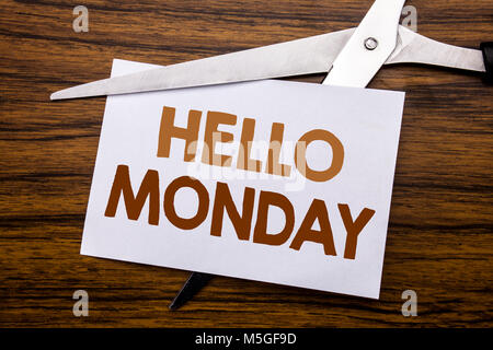 Hand writing text caption inspiration showing Hello Monday. Business concept for Day Week Start Written on note, wooden with colourful scissors meanin Stock Photo