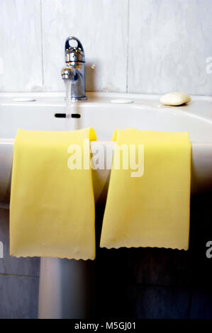 rubber gloves on the edge of a sink Stock Photo