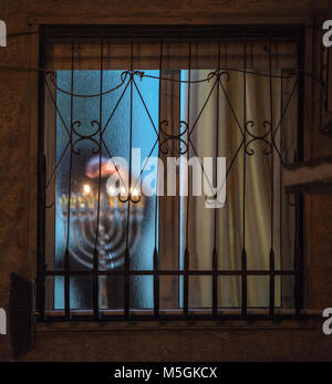 Orthodox Jew in black Hasidic costumes, lighting candle in the holiday of Hanukah in the old city of Jerusalem Israel Stock Photo