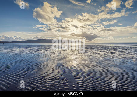 Bright dramatic clouds over sandy beach at low tide. Llandudno in North Wales. UK Stock Photo