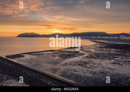 Raising sune over northern shore of Llandudno at low tide. North Wales, UK Stock Photo