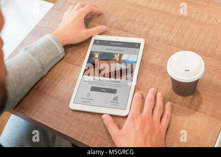 Real estate agency web site on property agent laptop. Coffee beside. Stock Photo