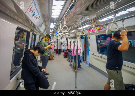 SINGAPORE CITY, SINGAPORE - NOV 13, 2013: Indoor view of rail commuters ride a crowded Mass Rapid Transit MRT train through the city centre. Opened in 1987 the MRT has a daily ridership of 2.8 million passengers Stock Photo