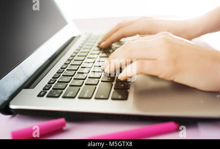 Woman and fruit diet while working on computer in office. Female hands on keyboard. Side view on woman. Trendy color pink desk. Woman, stilish workpla Stock Photo