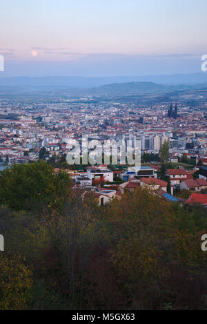 moonrise over the city of Clermont Ferrand with pink and blue clouds Stock Photo