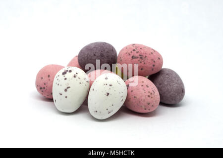 Ten Chocolate Candy covered Easter Eggs in a pile and isolated on a white background. The eggs at the front of the mage are in full focus and gradualy Stock Photo