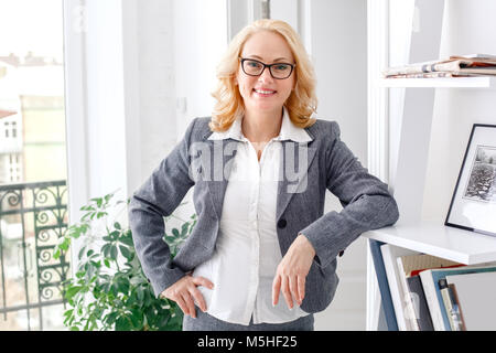 Woman psychologist portrait standing at casual home office looking camera smiling Stock Photo