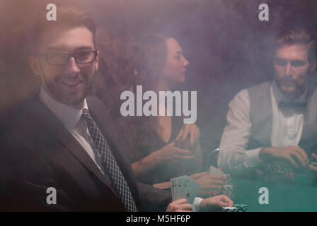 businessman showing four aces sitting at the craps table in the casino Stock Photo