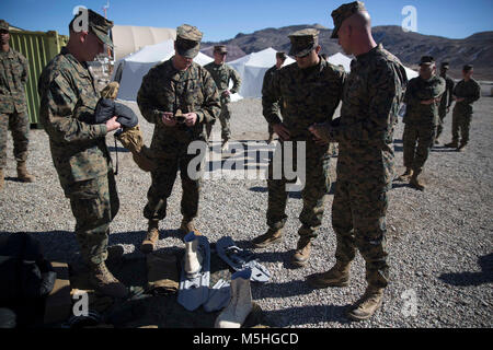 Lance Cpl. Richard Jenkins, a supply representative with Combat Logistics Regiment 25, 2nd Marine Logistics Group, explains how to properly use cold weather gear to Brigadier General David W. Maxwell, the commanding general of 2nd MLG and his staff at Marine Corps Mountain Warfare Training Center, Bridgeport, Calif., Feb. 7, 2018. The visit enabled Maxwell to observe the well-being and readiness of the unit preceding their training iteration where they learned survival skills, how to traverse mountainous terrain and cold weather weapons maintenance. The training will prepare the Marines for jo Stock Photo