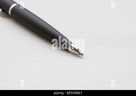 black ballpoint pen nib,on a white notebook background Stock Photo
