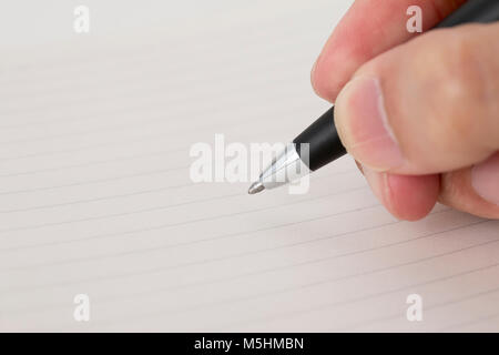 a ballpoint pen was holding in hand ready to writing in note book Stock Photo