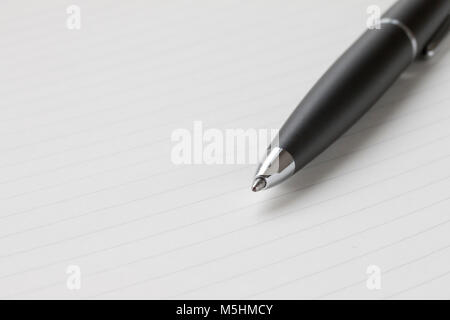 black ballpoint pen nib,on a white notebook background Stock Photo